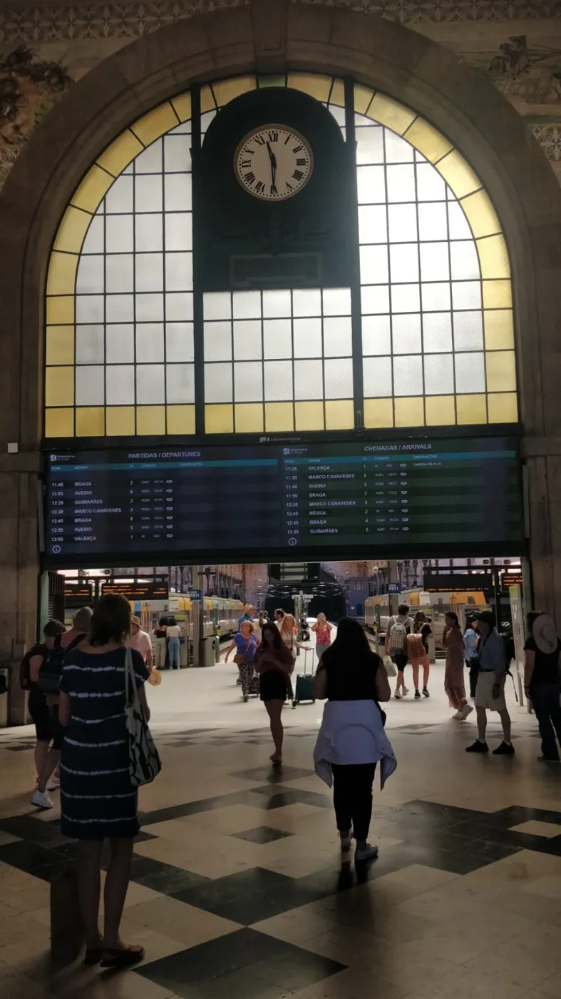 Travellers inside the historic São Bento railway station in Porto