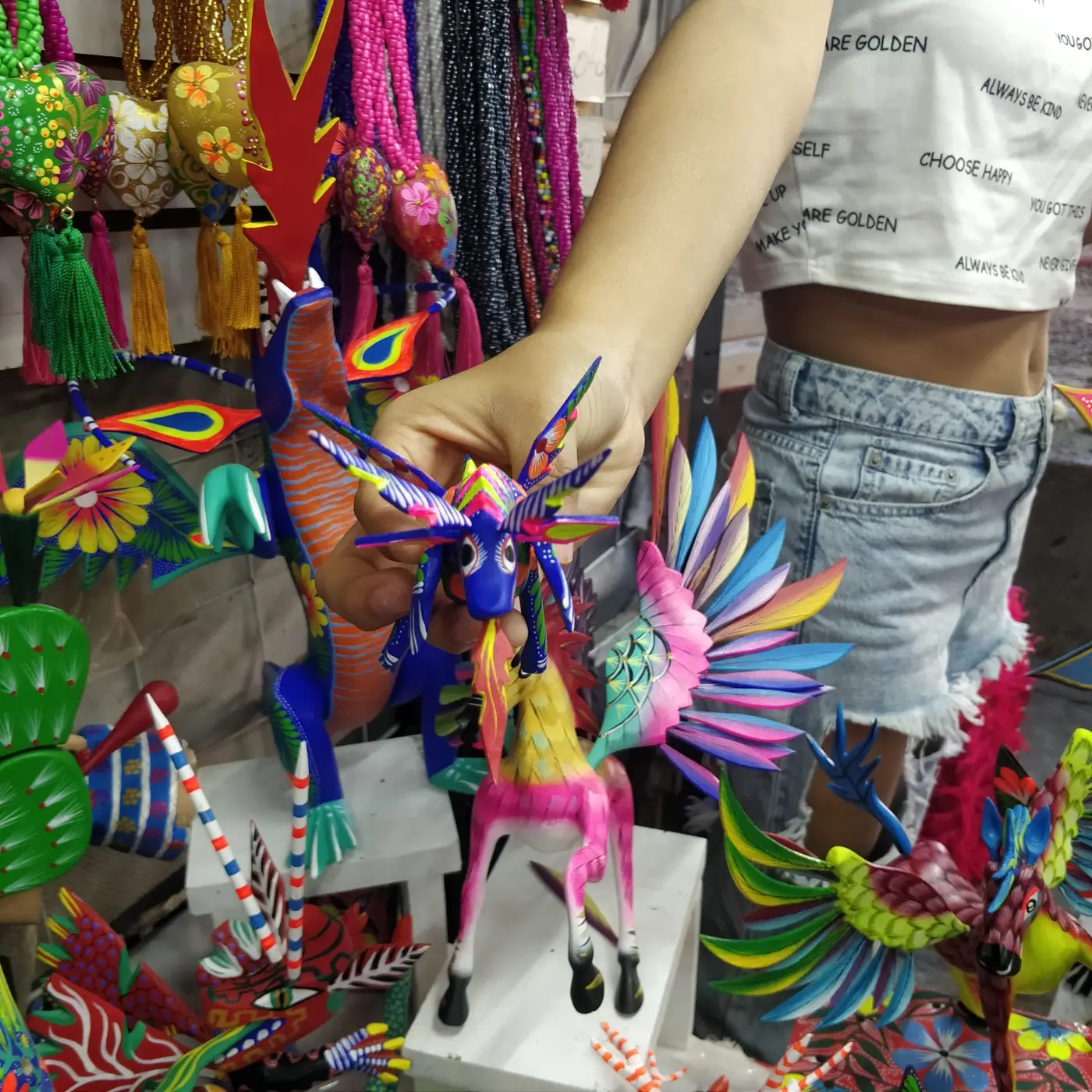 A colourful hand-painted alebrije in a market